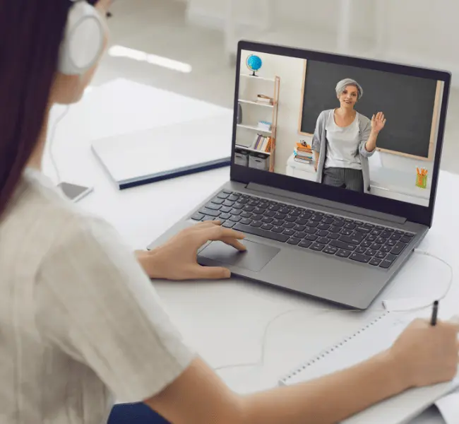 A student wearing headphones in an online consulting session with an ISEC expert for university application preparation