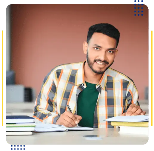 A male student taking notes in a classroom, representing popular STEM and Business courses in the United States