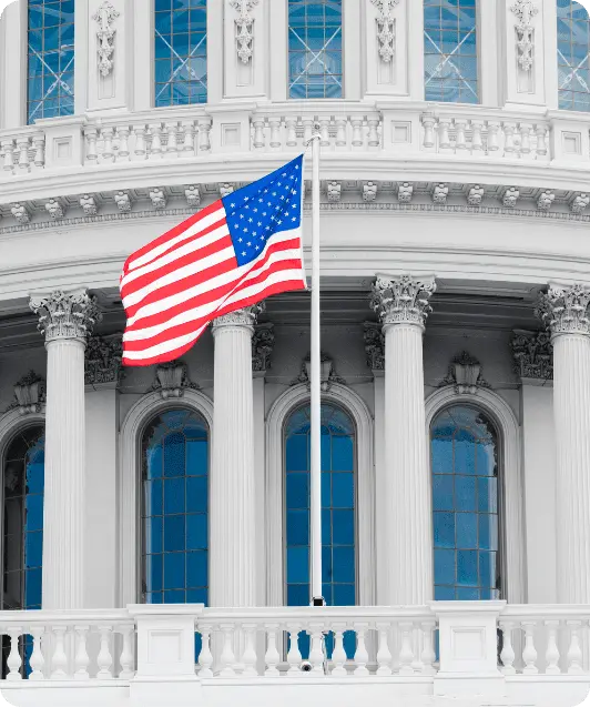 The American flag waving in front of a white neoclassical government building, representing USA study permits